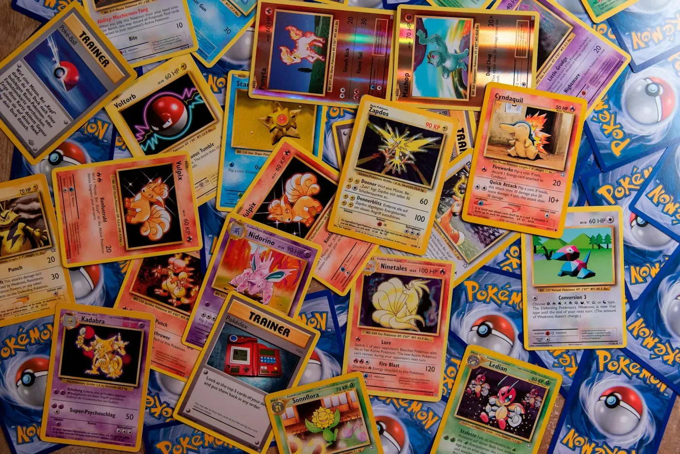 Cartes Pokémon de l’ère Wizards of the Coast, en anglais et en allemand, étalées en vrac