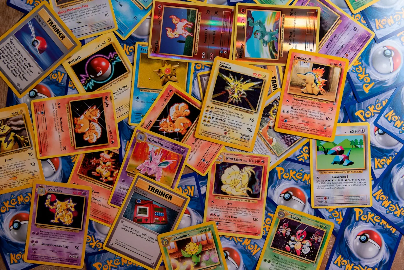 Collection hétéroclite de cartes Pokémon étalées — holographiques vintage et cartes modernes mélangées.